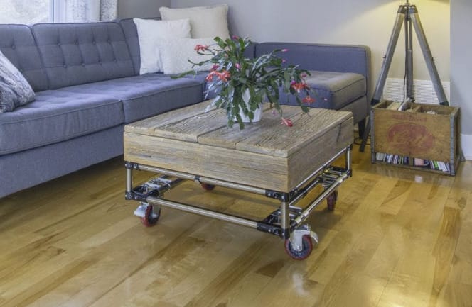 A mobile coffee table with a wood top.